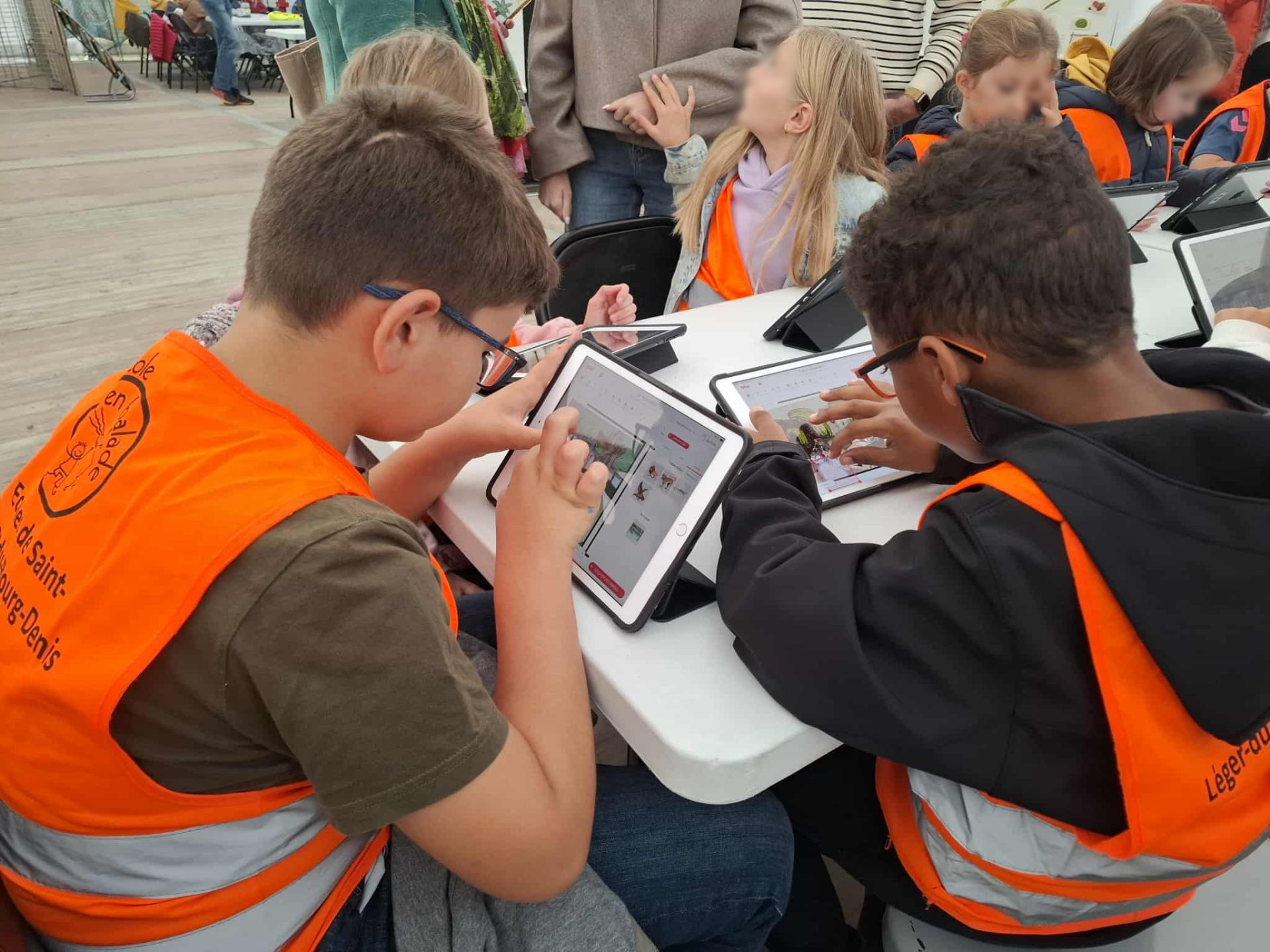Enfants participant à un atelier de bande dessinée numérique sur tablette.